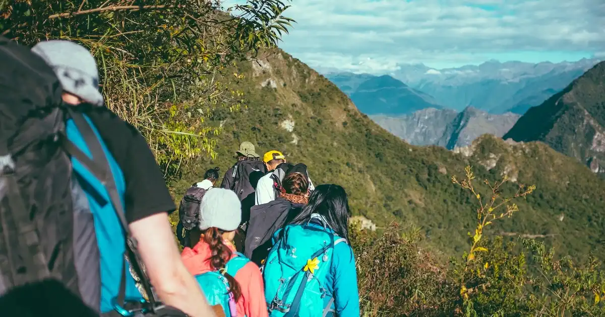 Several hikers walking on a trail in the mountains